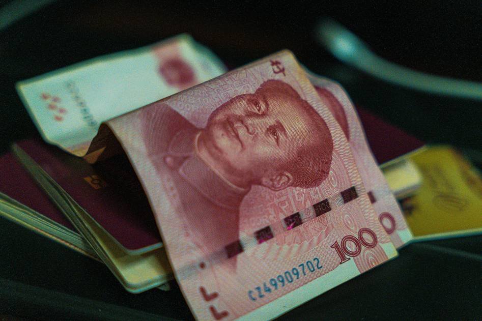 Traveler exchanging currency at airport counter with insurance documents