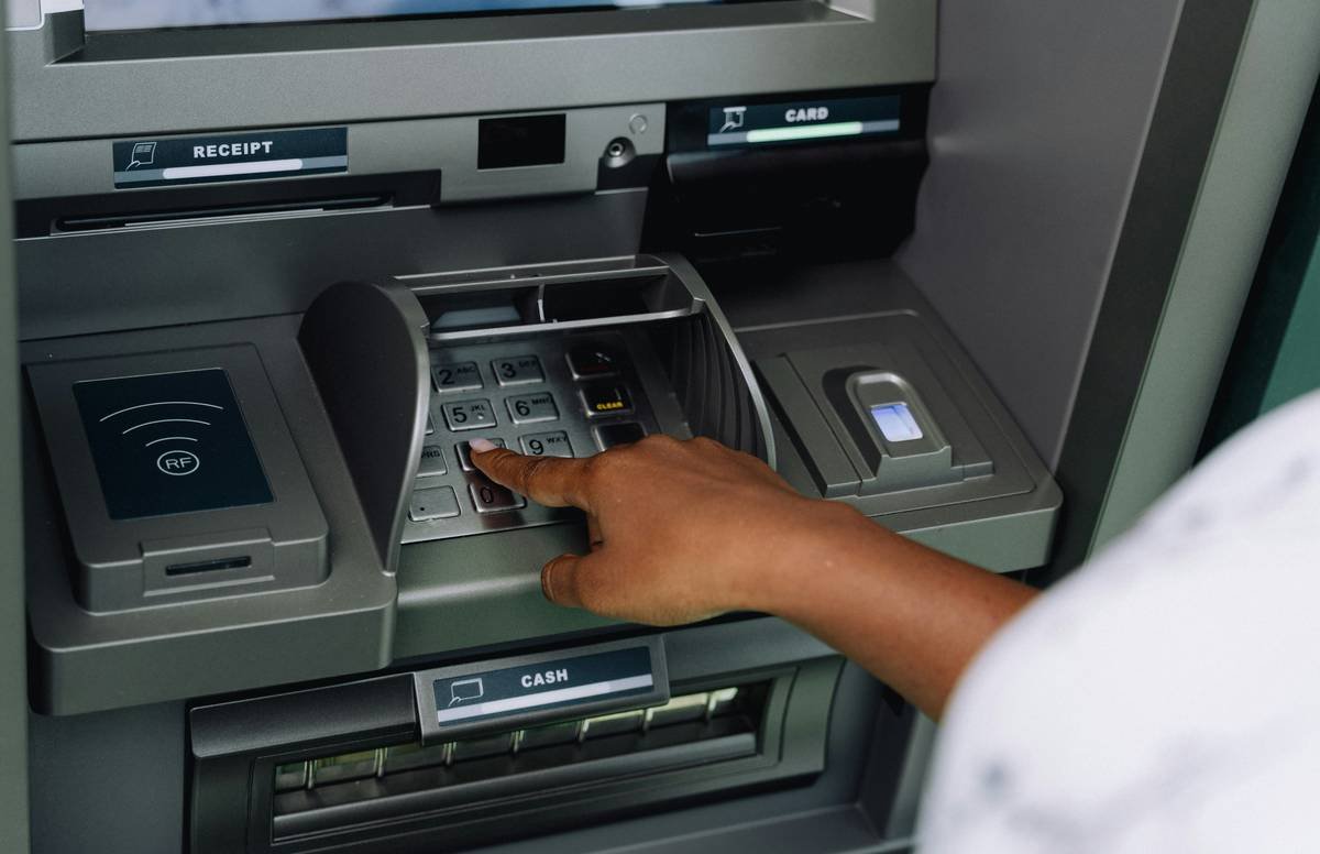 Traveler receiving emergency cash withdrawal at airport counter with agent